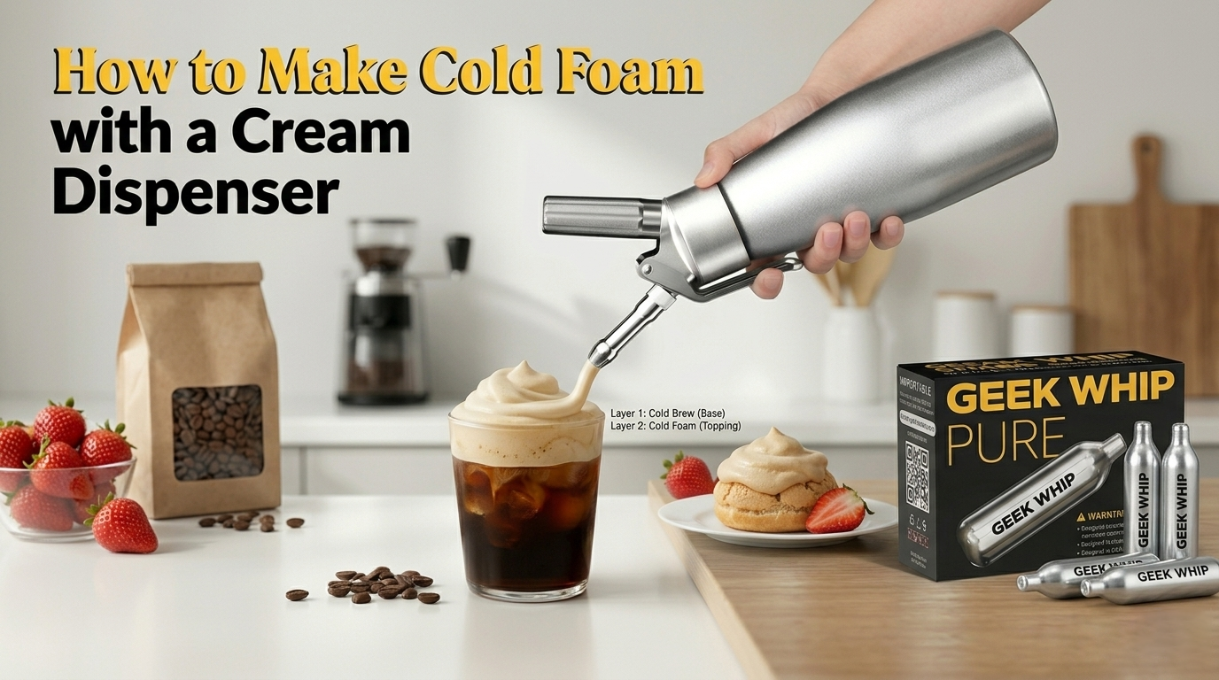 A horizontal blog banner showing a hand using a cream dispenser to top a glass of cold brew coffee with thick cold foam. A box of GEEK WHIP PURE N2O chargers is positioned on the right side of the kitchen counter.